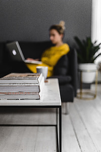 Young woman sitting on the sofa and working on her laptop thumbnail