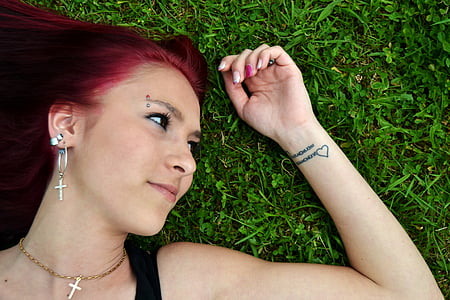 woman wearing black spaghetti-strap top lying on green grass field thumbnail