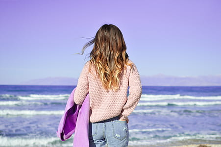 woman wearing pink knitted sweater standing near on beach thumbnail