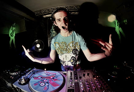 man standing beside DJ controller thumbnail