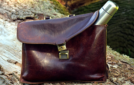 gray stainless steel vacuum flask on brown leather bag on brown wood trunk at daytime thumbnail