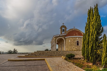brown concrete church under cloudy sky thumbnail