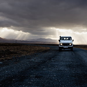 white SUV on road under gray sky during golden hour thumbnail