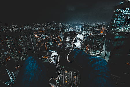 person with feet on balustrade over cityscape thumbnail