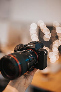 person holding Sony DSLR camera thumbnail