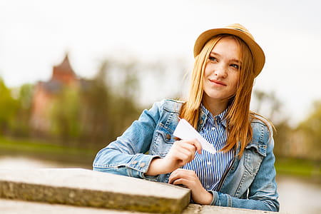 Selective Focus Photo of Woman Smiling Holding White Paper Airplane thumbnail