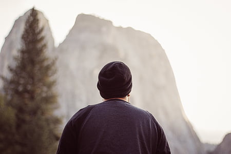 person wearing black cap facing rock formation thumbnail