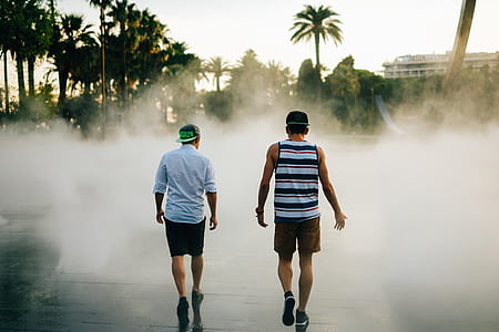 two men walking on pathway during fog thumbnail