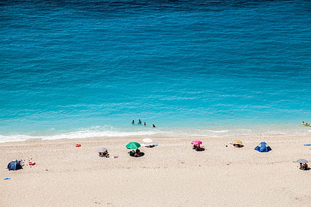 people on seashore sunbathing under daytime thumbnail