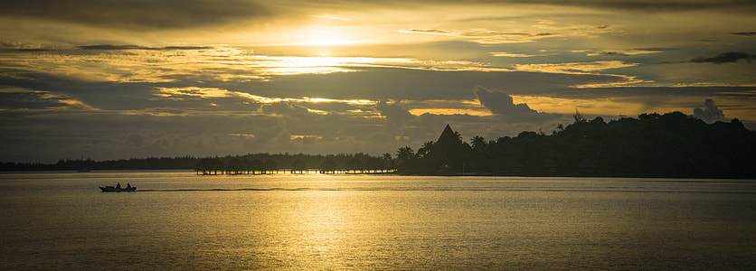 boat sailing on body of water during sunset thumbnail