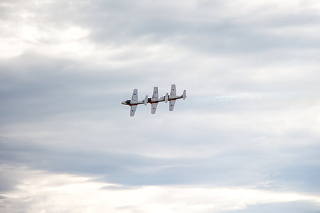 three flying white planes under cloudy sky during daytime thumbnail