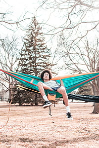 man in gray shirt lying on green hammock during daytime thumbnail