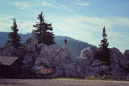 person standing on grey rock under blue sky thumbnail
