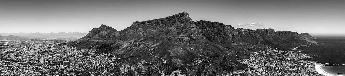 grayscale photo of city near mountain thumbnail