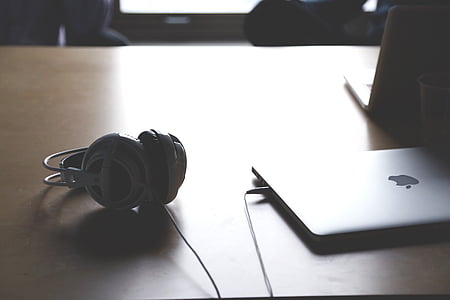 silver MacBook beside headphones on tagble thumbnail