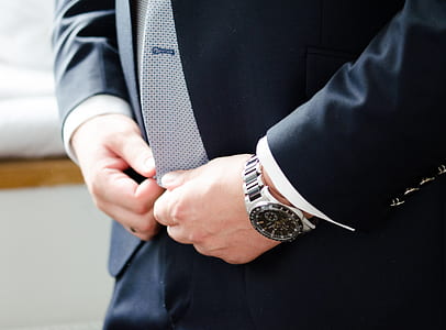 person wearing round silver-colored chronograph watch thumbnail