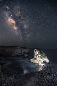 grey rock formation under starry sky thumbnail