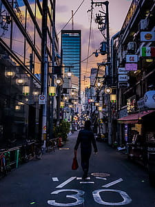 Person in Black Jacket Carrying Red Handbag thumbnail