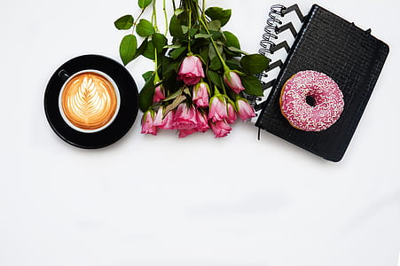 pink rose bouquet beside donut and cappuccino coffee thumbnail