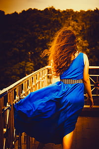 woman wearing blue sleeveless dress thumbnail