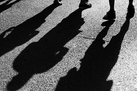 shadow of two people standing on concrete pavement thumbnail