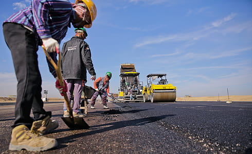four men working on concrete roadway holding shovel at daytime thumbnail