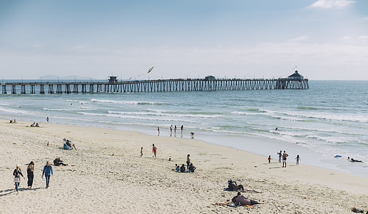 group of people playing on white sand seashore during daytime thumbnail