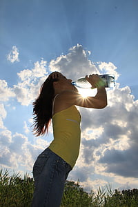 woman drinking water under blue sky thumbnail