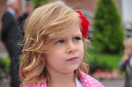 child wearing pink jacket with red flower on hair thumbnail