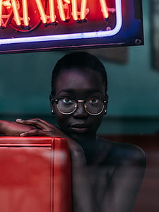 woman wearing eyeglasses under neon signage thumbnail