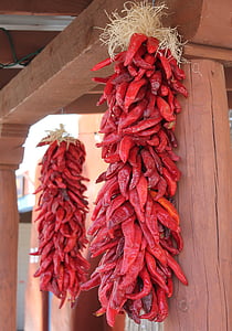red chillis hanging on wood thumbnail