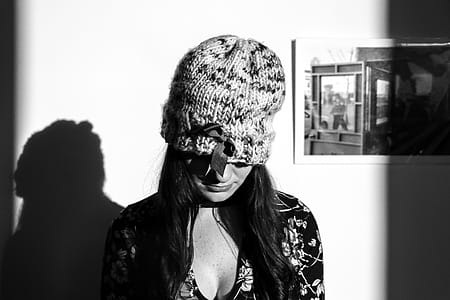 Greyscale Photo of Woman Wearing Knitted Hat and Floral Long-sleeved Top thumbnail
