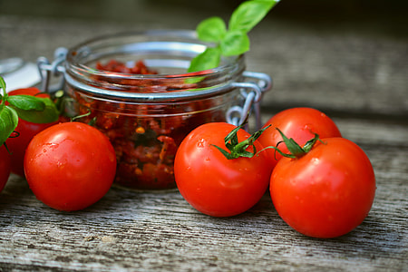 four tomatoes beside glass jar thumbnail