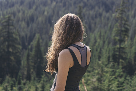 woman in black and gray tank top standing distance forest during daytime thumbnail