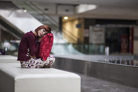 sitting woman on white leather bench inside building thumbnail