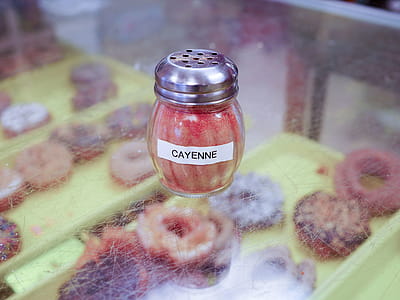 Cayenne spice in a glass shaker sitting in a donut shop. thumbnail