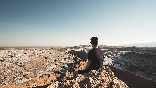 man sitting on rock formation outdoors thumbnail