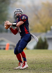 selective focus photography of football player holding football thumbnail