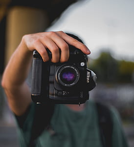 person holding black Nikon DSLR camera thumbnail