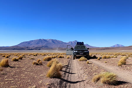 black Mitsubishi Montero SUV on desert road during daytime thumbnail