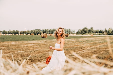 woman in white tube-top dress smiling thumbnail