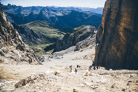 group of people walking near brown rocky mountain during daytime photo thumbnail