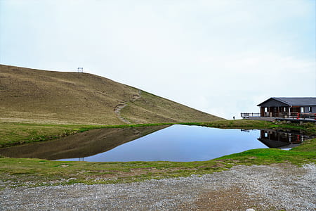 grey calm body of water beside house during daytime thumbnail