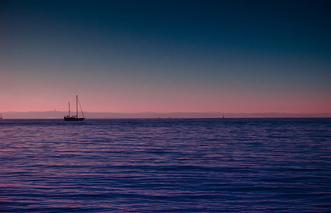 silhouette photo of ship on sea thumbnail