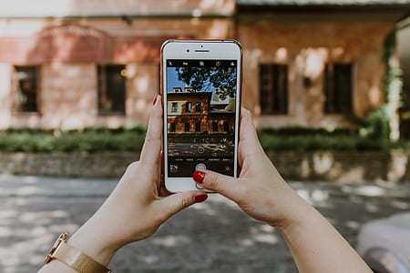 person taking photo of house using iPhone thumbnail