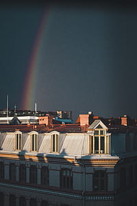 white and brown concrete building under rainbow thumbnail