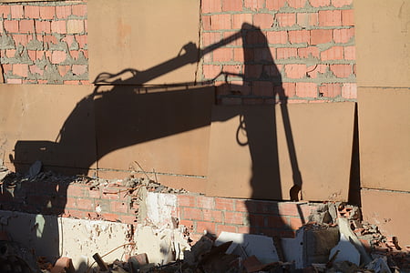 shadow of excavator on brick wall thumbnail