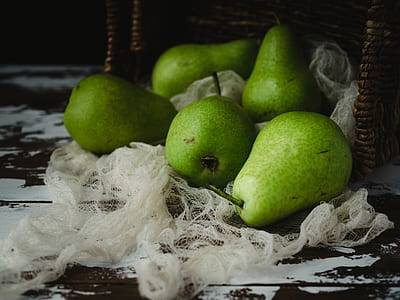 close-up photography of five green fruits beside brown wicker basket thumbnail