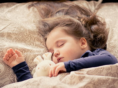 girl sleeping beside bunny plush toy during daytime thumbnail