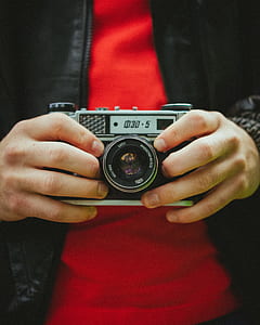 shallow focus photo of person holding gray SLR camera thumbnail